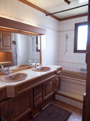 une salle de bain avec deux lavabos et une baignoire dans l'établissement Maison de famille sur l'île d'Oléron, à Dolus-d'Oléron