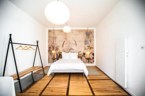 um quarto com uma cama e um quadro na parede em Appartement entier Le 1er Balnéothérapie Romantique em Bagnères-de-Bigorre