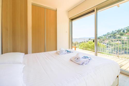 - une chambre avec un lit blanc et une grande fenêtre dans l'établissement SELECT'soHOME - Splendide Mazet avec vue mer à La Fossette - SOLE&MARE, au Lavandou
