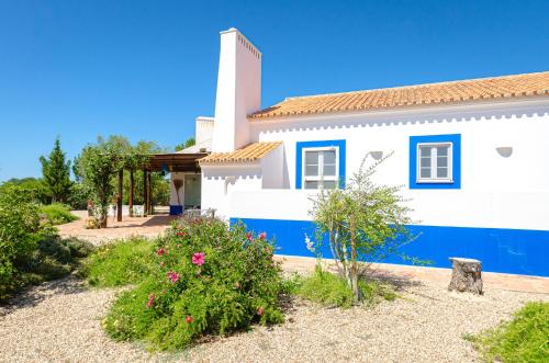 a white and blue house with a tower at Casa Oleandra in Melides