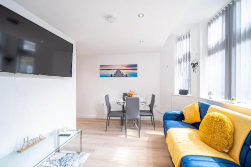 a living room with a blue couch and a table at Cozy Retreat near Hollingworth Lake, Milnrow, Rochdale in Rochdale