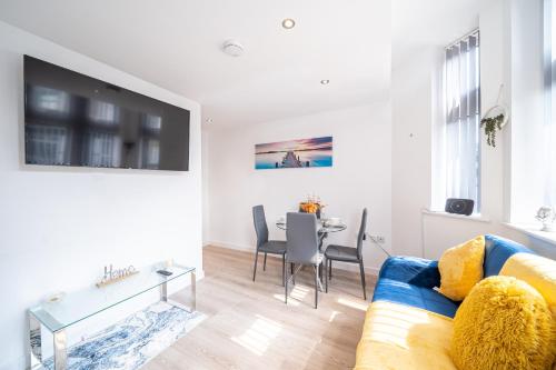 a living room with a blue couch and a table at Cozy Retreat near Hollingworth Lake, Milnrow, Rochdale in Rochdale