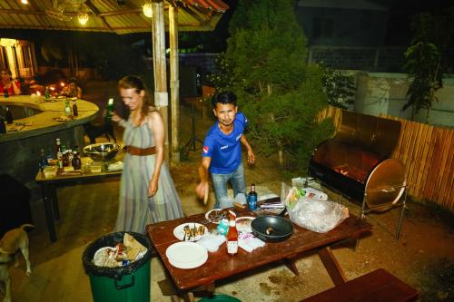 een man en een vrouw die naast een tafel staan bij Escape Divers - The Jungle in Ko Tao