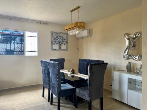 a dining room with a table and blue chairs at Casa moderna in Santiago de los Caballeros
