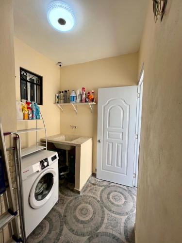 a laundry room with a washing machine and a white door at Casa moderna in Santiago de los Caballeros