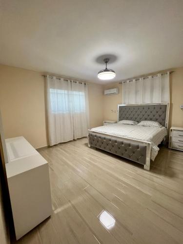 a bedroom with a large bed and a wooden floor at Casa moderna in Santiago de los Caballeros