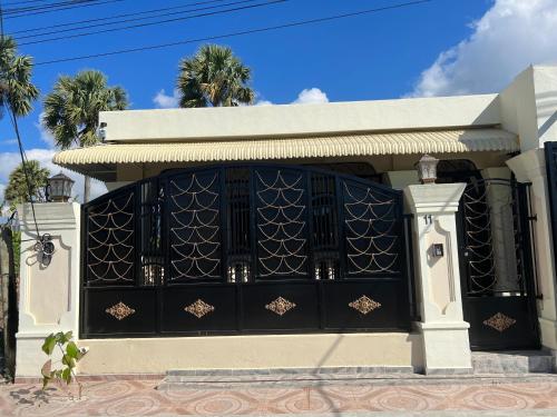 a black garage door on a house with palm trees at Casa moderna in Santiago de los Caballeros