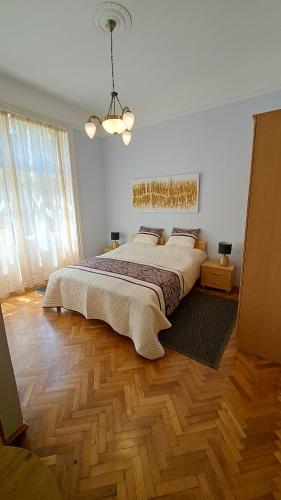 a bedroom with a large bed and a wooden floor at Apartmani Belsito in Lovran