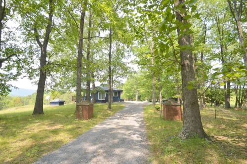 a dirt road leading to a house in a forest at Black Bear Cabin - Fire Pit, Grill, View, Pet Friendly, Fireplace, King Bed, Wifi, Game Room in Morton Grove