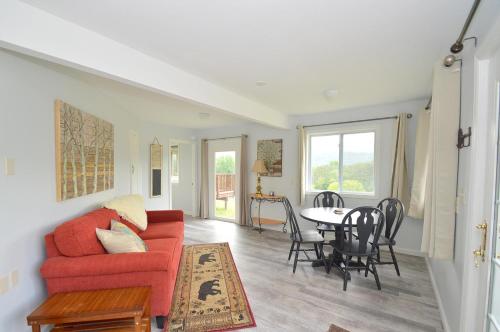 a living room with a red couch and a table at Black Bear Cabin - Fire Pit, Grill, View, Pet Friendly, Fireplace, King Bed, Wifi, Game Room in Morton Grove