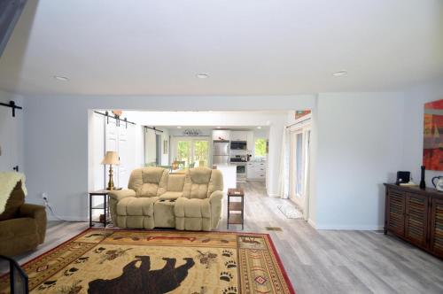 a living room with two chairs and a rug at Black Bear Cabin - Fire Pit, Grill, View, Pet Friendly, Fireplace, King Bed, Wifi, Game Room in Morton Grove