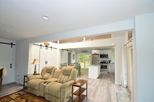 a living room with a couch and a kitchen at Black Bear Cabin - Fire Pit, Grill, View, Pet Friendly, Fireplace, King Bed, Wifi, Game Room in Morton Grove