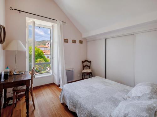 a bedroom with a bed and a desk and a window at Chalet Elisa Chambre d'Hôtes in Sare