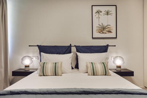 sypialnia z białym łóżkiem z 2 lampami w obiekcie Galadriel Apartments w mieście Káto Yerakaríon