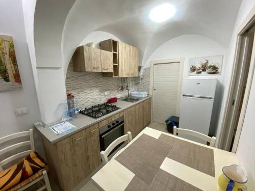 een keuken met een tafel en een fornuis top oven bij La casa sotto il castello! in Carovigno