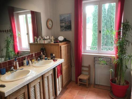une salle de bain avec deux lavabos et un grand miroir dans l'établissement Bastide récente, jardin et piscine Aix-en-Provence, à Aix-en-Provence