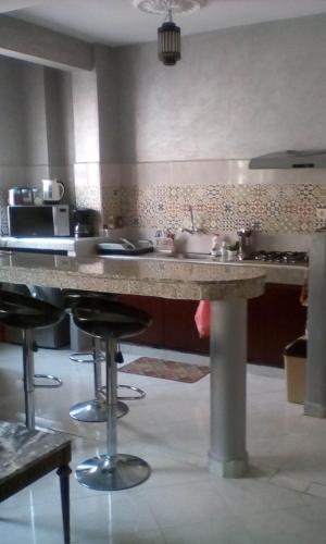 een keuken met een groot aanrecht met krukken bij appartement cosy à Marrakech in Marrakesh