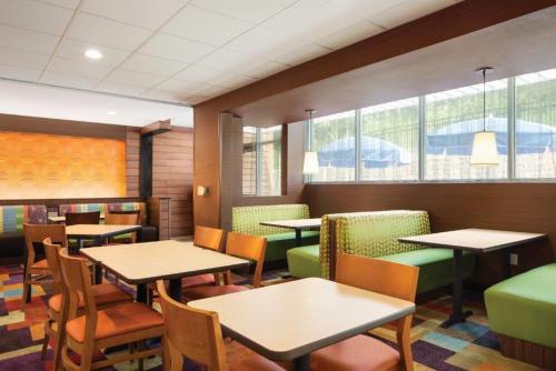 a dining room with tables and chairs and windows at Fairfield Inn & Suites by Marriott Athens in Athens