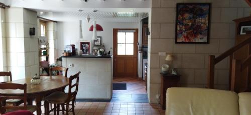une cuisine et une salle à manger avec une table et des chaises dans l'établissement Maison de campagne entre Loire et vignes, à  Charcé-Saint-Ellier-sur-Aubance