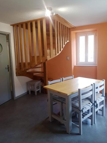 une salle à manger avec une table et un escalier dans l'établissement Gites Communaux à Lourdios, à Lourdios-Ichère