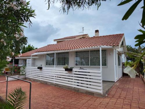 a white house with a red roof at La Caletta di Afrodite in Calabernardo