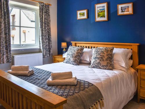 una camera da letto con un grande letto con pareti blu di The Old Workshop a Keswick