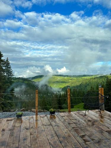 a wooden deck with a view of the mountains at La KOLTAU A-Frame in Mărişel