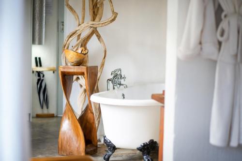 a bathroom with a white tub and a sink at Qambathi Mountain Lodge in Kamberg Valley