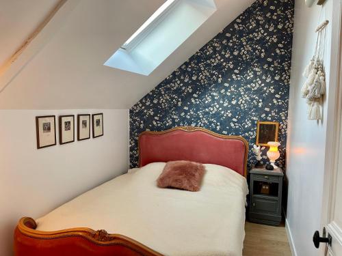 sypialnia z łóżkiem i niebiesko-białą ścianą w obiekcie Petit gîte d’arrière-cour au pied du Château w mieście Combourg