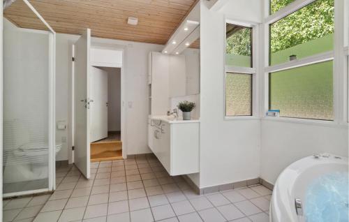 baño con bañera, lavabo y ventana en Rubinsen Skovhuse, en Hasle
