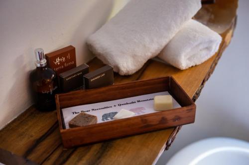 a wooden tray with soap and other items on a shelf at Qambathi Mountain Lodge in Kamberg Valley