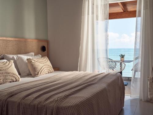 a bedroom with a bed with a view of the ocean at Villa Grimani in Laganas