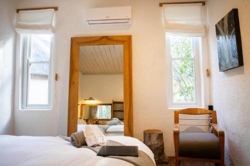 a bedroom with two beds and two windows at Qambathi Mountain Lodge in Kamberg Valley