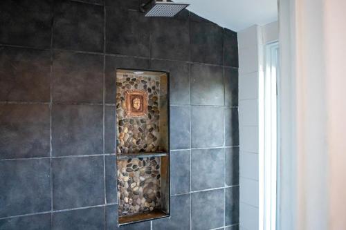 a shower with a tile wall with a niche at Qambathi Mountain Lodge in Kamberg Valley