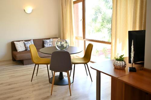 - un salon avec une table, des chaises et un canapé dans l'établissement Apart Hotel Primavera 2, à Primorsko