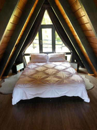 een slaapkamer met een bed in een tent bij La KOLTAU A-Frame in Mărişel