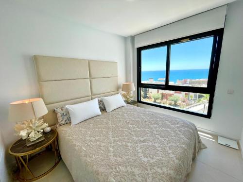 sypialnia z dużym łóżkiem i dużym oknem w obiekcie Luxury 3 Bedroom Penthouse w mieście Fuengirola
