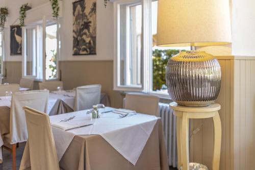 a dining room with tables and a lamp on a table at Hotel Quisisana in Vada