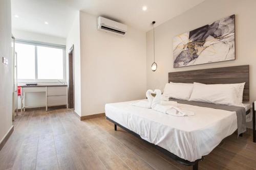 Un dormitorio con una cama con un animal de toallas. en Studio 42 with kitchenette at the new Olo living, en Paceville
