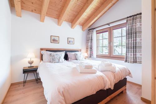 Un dormitorio con una cama grande y una ventana en Chalet Ulysse, en Zermatt