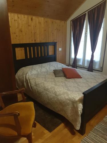 a bedroom with a bed and a chair and a window at Casa Maria in Cincu