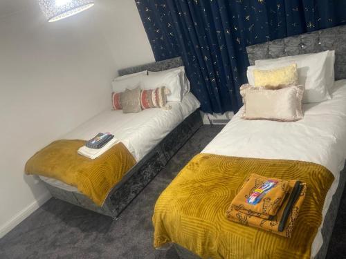 2 Betten nebeneinander in einem Zimmer in der Unterkunft The Leckhampton - Company and Family Stays Chester Road in Walsall