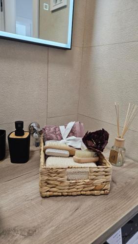 a basket of towels on a counter with a mirror at Apartman Nella with sea wiew in Zadar