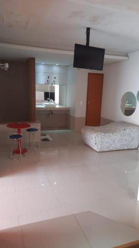 een kamer met een bed, een tafel en een keuken bij MOTEL HORA EXTRA in Jataí
