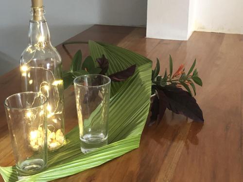a bottle and glasses on a table with lights at Seacret Studios - Cozy Jamaican Retreat apts in Negril
