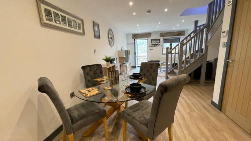 a dining room with a glass table and chairs at Chapel row 4 in Wirksworth