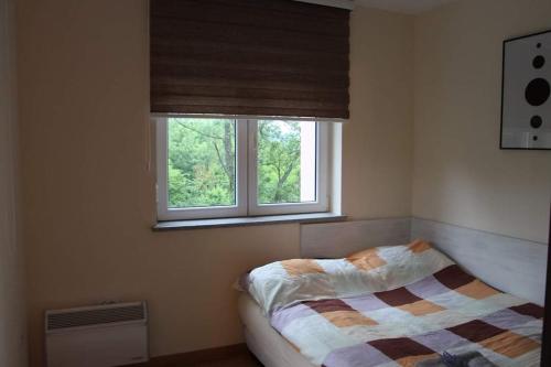 a bedroom with a bed and a window at Perla Lux in Vrnjačka Banja