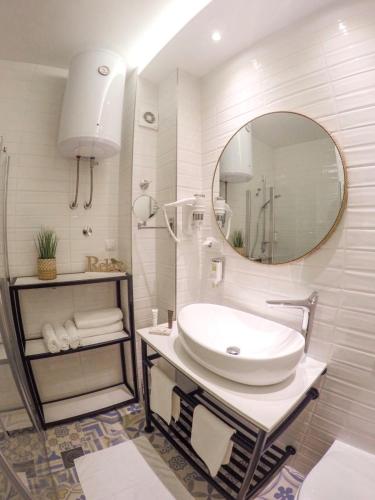 a white bathroom with a sink and a mirror at Platinum_Luxury_Apartment II in Teslić