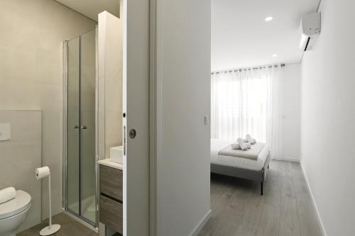 - une salle de bains avec toilettes et un lit dans une chambre dans l'établissement Blissful Beach Getaway, à Nazaré