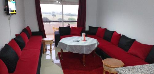 - un salon avec un canapé rouge et une table dans l'établissement Marina golf assilah مارينا كولف أصيلة, à Assilah